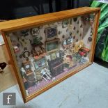A framed and glazed diorama modelled as a furnished room with pictures, ornaments and clocks,