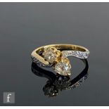 An early 20th Century 18ct diamond two stone cross over ring, claw set old cut stones, pear and