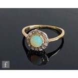 An early 20th Century 18ct opal and diamond cluster ring, central opal collar set within a border of