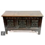 A late 17th Century to early 18th Century oak coffer, with triple fielded panel front carved with