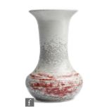 A Ruskin Pottery dove grey high fired vase of globe and shaft form with ox blood streaking,