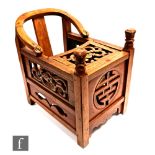 A Chinese Huanghuali style child's chair, the carved scroll yoke back extending to reticulated and