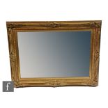 A late 20th Century swept gilt framed rectangular bevel-cut wall mirror, bears Masterpiece Fine