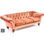 A Victorian Chesterfield type three seat sofa or settee, upholstered in pink button down dralon over