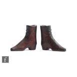 A pair of 19th Century carved wooden boots with steel pique eyelet decoration, height 4cm. (2)
