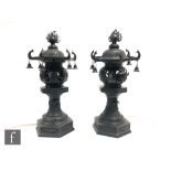 A pair of early 20th Century Chinese cast metal pedestal censers, each modelled as a pagoda raised