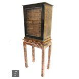 A late 19th to early 20th Century glazed fronted pine collectors cabinet in a scumble painted finish