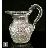 An early 19th Century clear crystal jug of ovoid form with an applied loop handle and thumb flat,