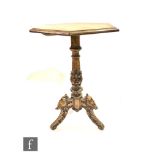 A Victorian octagonal walnut tripod table on turned carved pedestal and mask and leaf carved