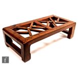 A Chinese Kang low table of small proportions, the block feet rising to a tubular reticulated top