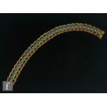 A 14ct turquoise bracelet, twenty eight individually collar set stones to open chevron panels, total