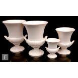 A set of four mid 20th Century Wedgwood campana urns each glazed in moonstone white, comprising a
