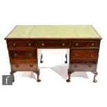 An early 20th Century mahogany twin pedestal desk, with green leather writing surface above an