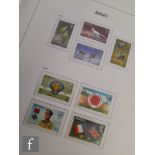 A collection of Queen Elizabeth II Jersey commemorative postage stamps, dating from 1969 through