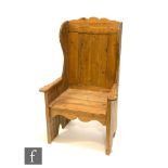 A 20th Century pine lambing chair, high back, shaped arms and open ends, height 122cm.