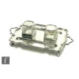 A hallmarked silver twin handled rectangular desk stand with twin glass well and pen rests, all