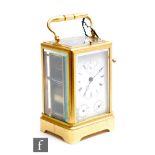 An early 20th century French brass repeater carriage clock striking on a bell, the white enamel dial