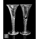 A pair of 20th Century wine glasses in the 18th Century style with drawn trumpet bowl above a