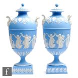 A pair of Wedgwood Dancing Hours Jasper ware twin handled pedestal vase and covers, each decorated