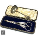 A cased pair of hallmarked silver grape scissors with reeded stems, with a small sauce ladle,