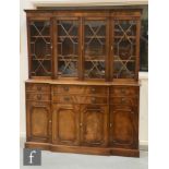 A Regency style mahogany breakfront bookcase, the four astragal glazed doors below a fluted dentil