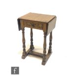A 20th Century oak drop leaf occasional table in the manner of Titchmarsh and Goodwin, fitted with a