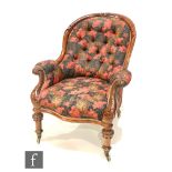 A Victorian mahogany open scroll arm chair on turned carved legs, upholstered in a printed poppy