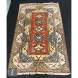 A 20th Century Caucasian rug with central panel incorporating four diamond floral lozenges on a