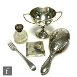 Five items of silver, a twin handled cup, a fork, a cigarette case, a hair brush and a silver topped