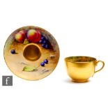 A matched Royal Worcester Fallen Fruits cabinet cup and saucer, the interior of the cup decorated