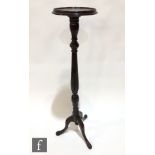 An Edwardian carved mahogany torchere, turned baluster pedestal on tripod legs, height 124cm.