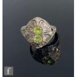A 9ct hallmarked Edwardian style peridot and diamond ring, pierced domed head with two central
