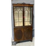 An Edwardian mahogany glazed display cabinet enclosed by a pair of cloud shaped bar glazed doors