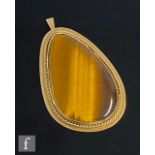 A 9ct hallmarked pendant tear shaped tiger's eye within a rope twist and plain gold border, total
