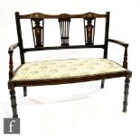 An early 20th Century marquetry inlaid two seater settee, pierced vase splat over a tapestry seat on