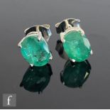 A pair of silver emerald stud earrings, claw set oval set stones, length approximately 8mm.