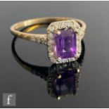 A 9ct hallmarked amethyst and diamond cluster ring, central emerald cut amethyst, length 7mm, within