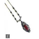 A 1930s silver marcasite and carnelian open work pendant, length of drop 5cm, length of chain