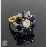 An 18ct sapphire and diamond cluster ring, central brilliant cut diamond, weight 0.65ct, within a