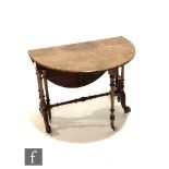 A Victorian figured walnut oval drop flap Sutherland table on twin fluted pillar supports and carved