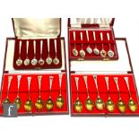 Four cased sets of six hallmarked silver and silver gilt teaspoons each with enamelled foliate