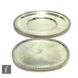 An oval card waiter of plain form with central engraved initial within gadroon borders, length 15cm,
