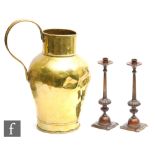 A pair of 20th Century bronzed candlesticks, tapering columns over stylised and foliate bases,