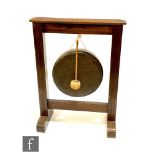 A 1930s oak framed brass gong and stand with beater, on trestle base, width 66cm.