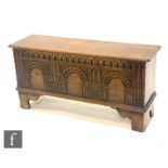 A 20th Century oak coffer or blanket chest attributed to Titchmarsh and Goodwin, with lunette carved