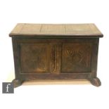 A small 18th Century style and later constructed oak coffer on stiles, twin carved panelled front,