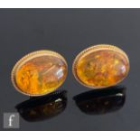 A pair of 9ct oval Baltic amber earrings, cabochon cut amber to a plain setting, weight 5g, length