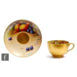 A Royal Worcester Fallen Fruits cabinet cup and saucer decorated by Austin, the interior of the