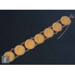 A late 20th Century sovereign bracelet comprising seven loose mounted George V full sovereigns,