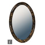 Unknown - An Art Deco bandalasta wall mirror, of oval form with variegated swirling black and